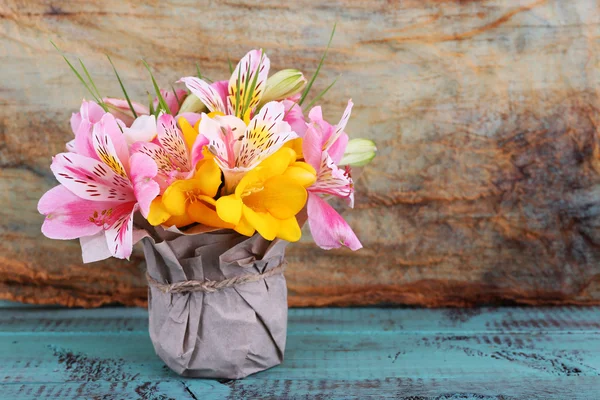 Vackra blommor i vas på trä bakgrund — Stockfoto