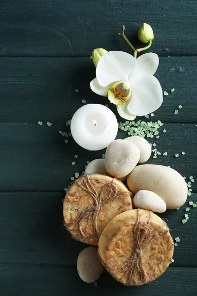 Martwa natura z piękny kwitnący storczyk kwiat, lecznictwa uzdrowiskowego i kamyki, na drewniane tła — Zdjęcie stockowe