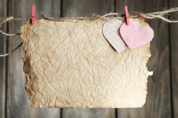 Bright hearts and card hanging on rope on wooden background — Stock Photo, Image