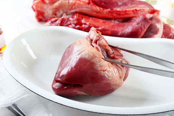 Орган сердца в металлическом подносе с инструментами на столе крупным планом — стоковое фото