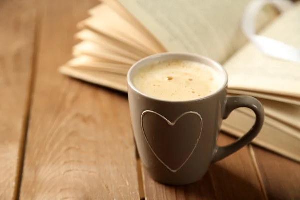 Natureza morta com xícara de café e livro, em mesa de madeira — Fotografia de Stock