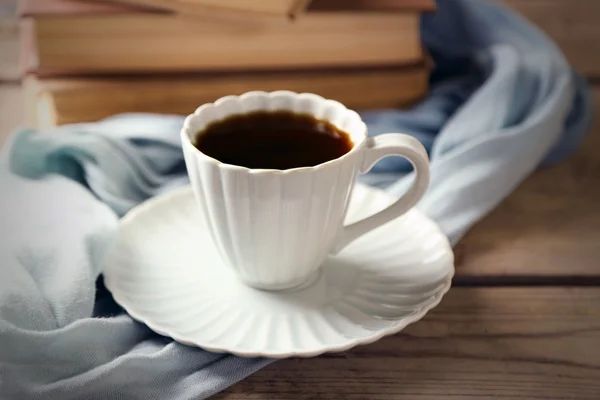 Still life with cup of coffee and books, on wooden table