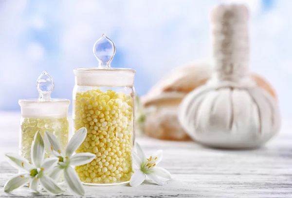 Sea salt, blommor och spa behandling på trä färgtabell på ljus bakgrund — Stockfoto