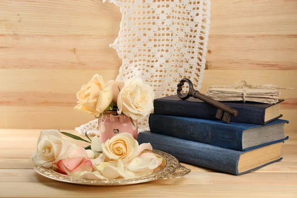 Rosas frescas con libro viejo, llave y letras sobre fondo de mesa de madera. Concepto Vintage —  Fotos de Stock