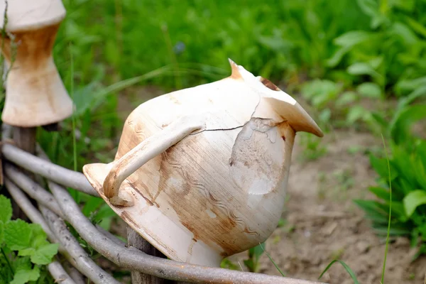 Cerca rústica de mimbre con olla vieja en el jardín en el fondo de la hierba — Foto de Stock