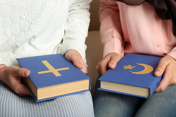 Dois amigos segurando livros com símbolos religiosos — Fotografia de Stock