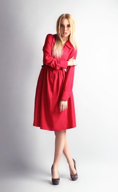 Etkileyici genç model gri arka plan üzerinde Kırmızı elbiseli