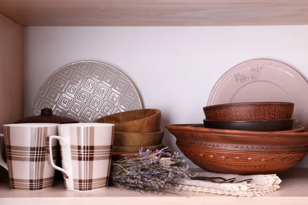 Utensilios de cocina y vajilla en estante de madera — Foto de Stock