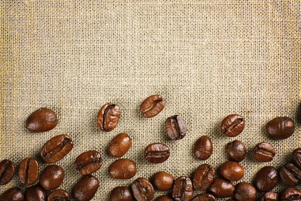 Quadro de grãos de café em fundo de pano de saco de cor — Fotografia de Stock