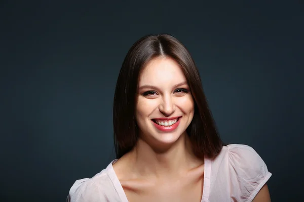 Portrait of beautiful young woman on dark background — Stock Photo, Image