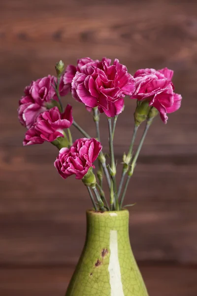 花瓶を木製の背景の上に紫色のクローブ — ストック写真