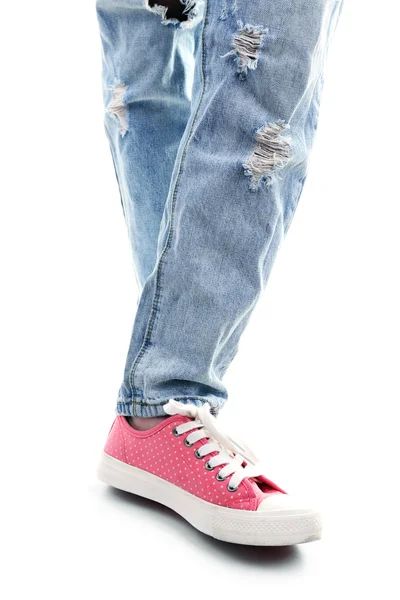 破れたジーンズと白で隔離ピンクのスニーカーの人 — ストック写真