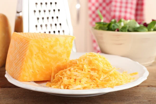 Queijo ralado na mesa de madeira na cozinha, close-up — Fotografia de Stock