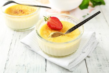Creme brulee tatlı taze çilek ve renk ahşap zemin üzerine nane yaprakları ile