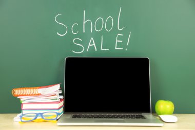 Masada yeşil yazı tahtası arka plan üstünde laptop