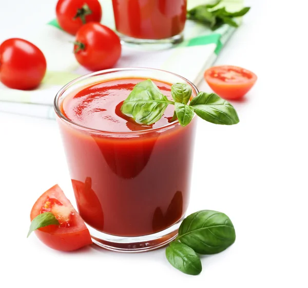 Vasos de jugo de tomate fresco en servilleta a cuadros, aislados en blanco —  Fotos de Stock