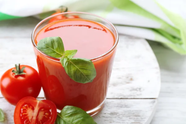 Стакан свежего томатного сока на деревянном столе, крупным планом — стоковое фото