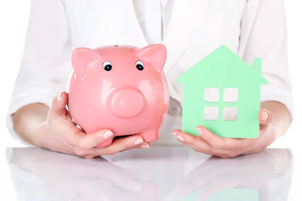 Woman holding model of house and piggy bank close up — Stock Photo, Image