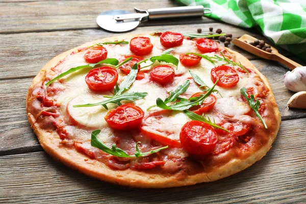 Heerlijke pizza met kaas en cherry tomaten op houten tafel, close-up — Stockfoto