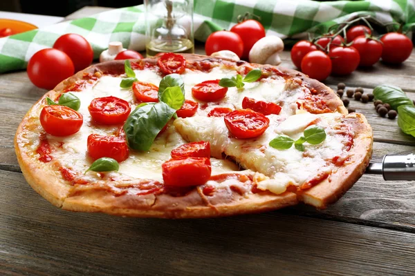 Deliziosa pizza con formaggio e pomodorini sul tavolo di legno, primo piano — Foto Stock