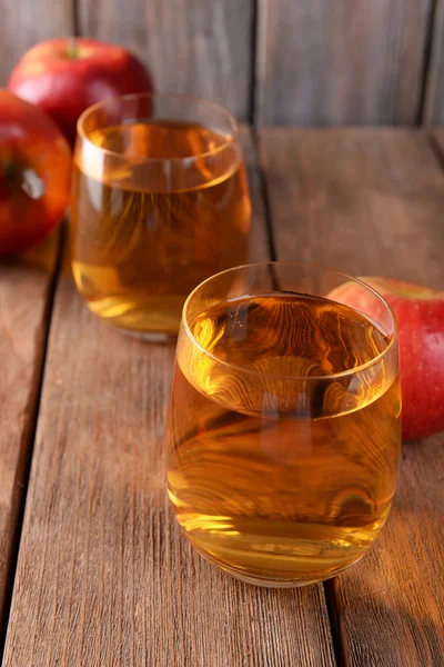 Vasos de jugo de manzana sobre fondo de madera — Foto de Stock