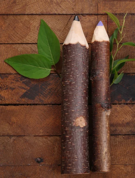 Lápices de madera con hoja sobre fondo de madera —  Fotos de Stock