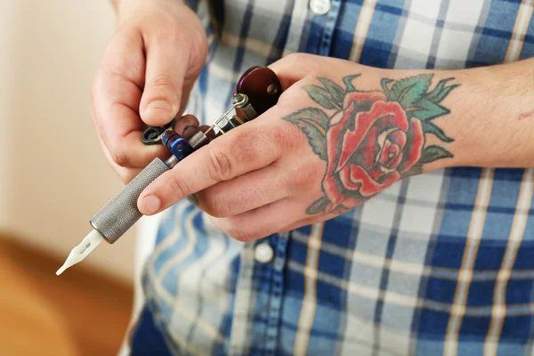 Mano del artista del tatuaje con la máquina del tatuaje, primer plano —  Fotos de Stock
