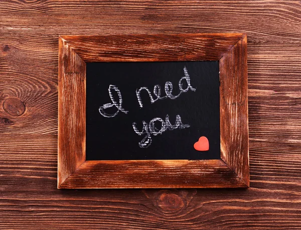 Inscription I NEED YOU on blackboard on wooden background — Stock Photo, Image