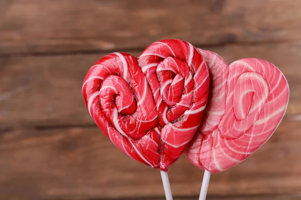 Bright lollipops in shape of heart on wooden background — Stock Photo, Image