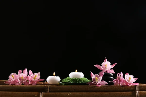Красива спа-композиція з квітами та свічками на чорному тлі — стокове фото