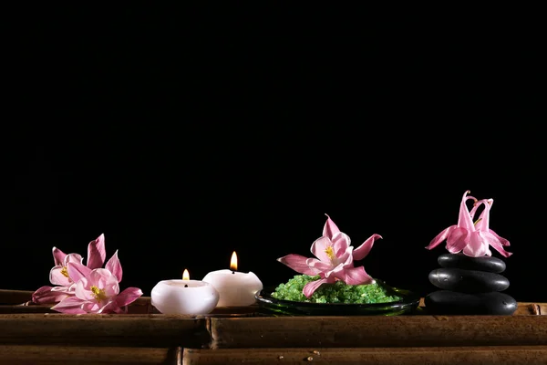 Hermosa composición de spa con flores y velas sobre fondo negro — Foto de Stock