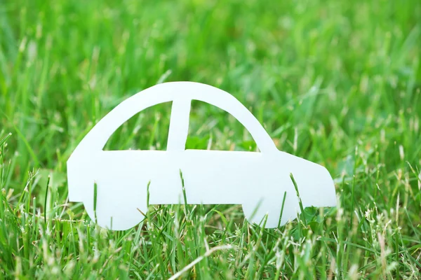 녹색 잔디 배경 위에 컷아웃 종이 자동차 — 스톡 사진
