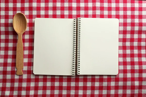 Open recipe book on color tablecloth background — Stock Photo, Image