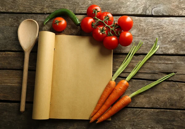 木製の背景にスパイス、野菜レシピ本を開く — ストック写真