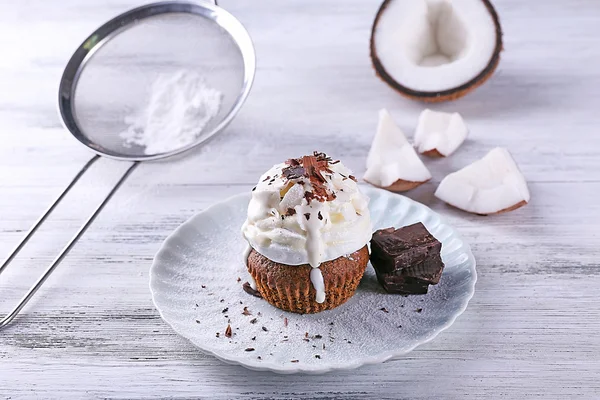 Delicioso cupcake de coco con chips de crema y chocolate sobre fondo de mesa de madera de color —  Fotos de Stock