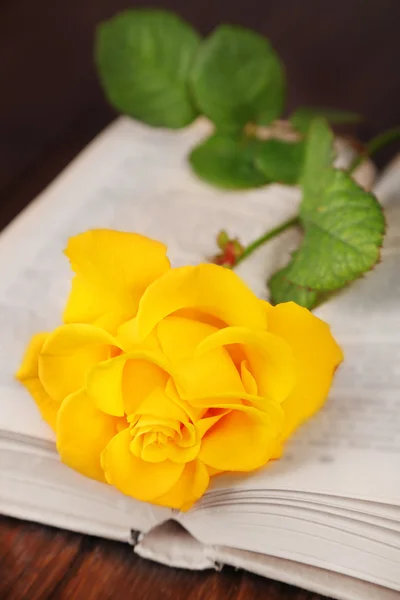 Boka med gul ros på träbord, närbild — Stockfoto