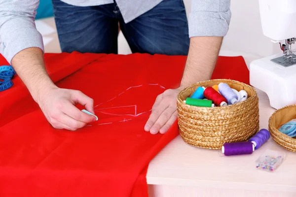Mężczyzna krawcowa krawiec tkaniny na stole — Zdjęcie stockowe