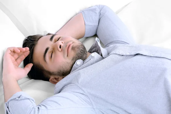 Cansado homem descansando na cama no quarto — Fotografia de Stock