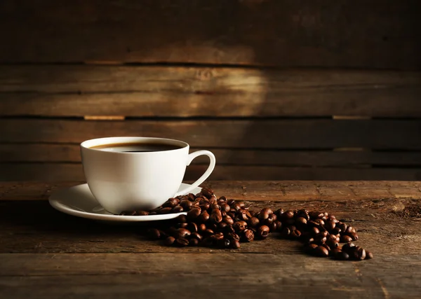 Taza de café con granos sobre fondo de madera — Foto de Stock