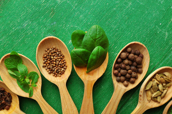 Wooden spoons with fresh herbs and spices