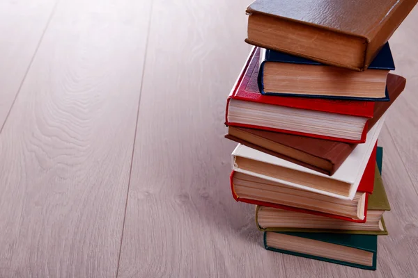 Tumpukan buku di latar belakang kayu — Stok Foto