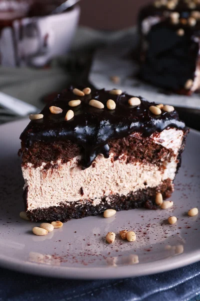 Deliziosa torta al cioccolato con glassa in piatto sul tavolo, primo piano — Foto Stock