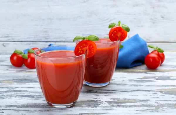 Glazen tomatensap met groenten op houten achtergrond — Stockfoto