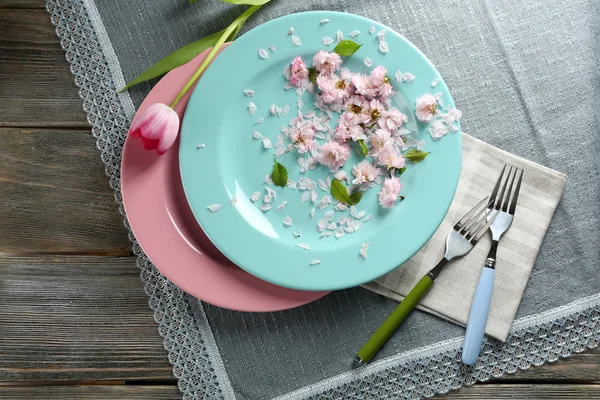 Louça com flores na mesa de perto — Fotografia de Stock