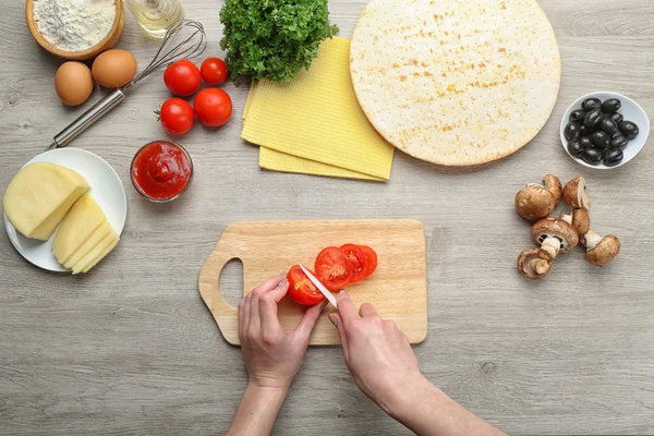 Female hands cooking pizza on wooden table, closeup — Stock Photo, Image