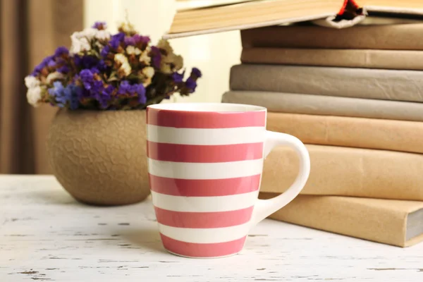 Libri, tazze e piante su tavola di legno, primo piano — Foto Stock