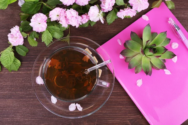 Чашка травяного чая с розовыми розами на деревянном столе, вид сверху — стоковое фото