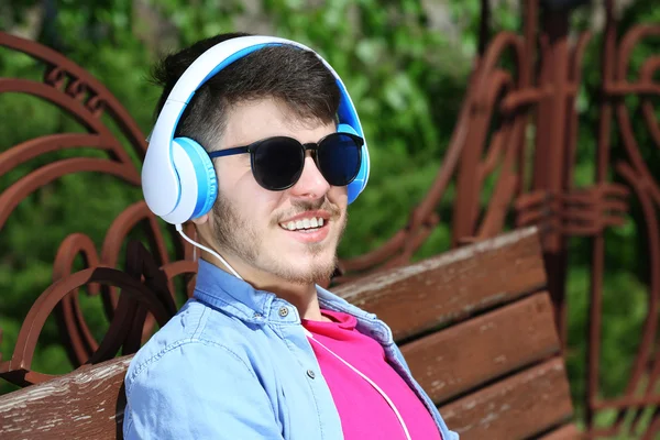 Άνθρωπος με ακουστικά που ακουμπά σε πάγκο — Φωτογραφία Αρχείου
