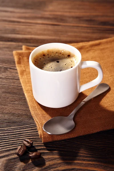 Xícara de café em guardanapo na mesa de perto — Fotografia de Stock