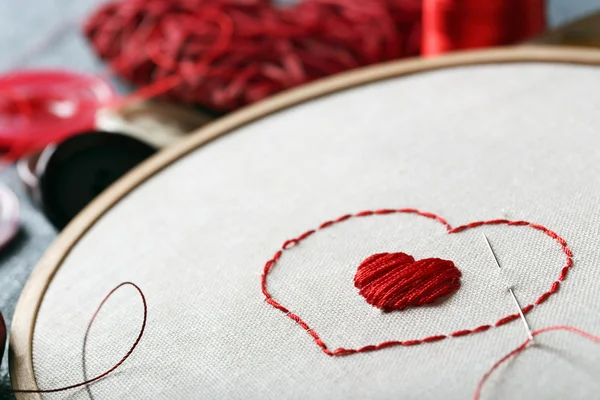 Вышивка обруч с холстом и красными нитями шитья — стоковое фото